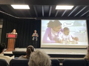 Ellie at a podium explaining her research